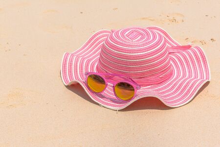 Summer accessories , hat , sunglasses on sand beachの写真素材