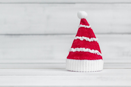 Santa claus hat standing on white wood over white rustic background with copy space for textの写真素材
