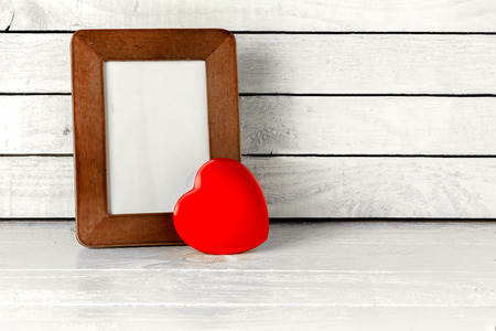 Photo Frame with Red Heart on table over white wood backgroundの写真素材