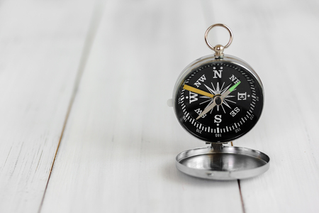 Compass on white wood table over white brick background with copy space.の写真素材