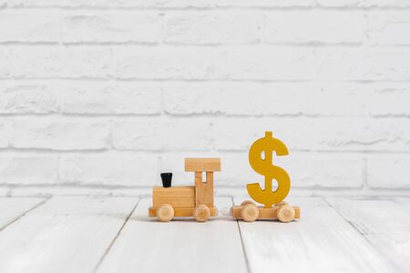Golden dollar sign on wood train over white background with copy spaceの写真素材
