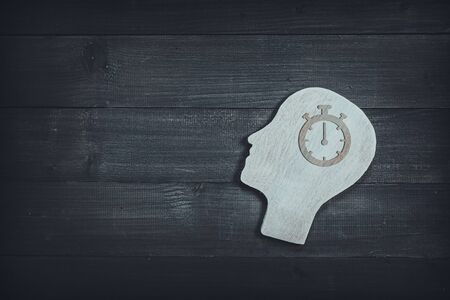Human head and face with timer watch  sign  on wood table background. Brain of thinking about time management , Symbol of Process and Positive Mind conceptの写真素材