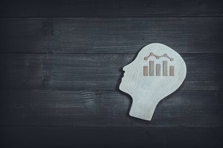 Human head and face with bar graph  sign  on wood table background. Brain of thinking about business , Symbol of Process and Positive Mind conceptの写真素材