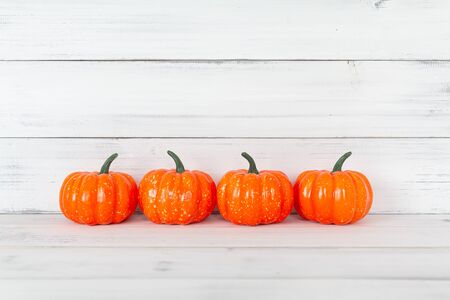 Orange pumpkin on white wood table with copy space.