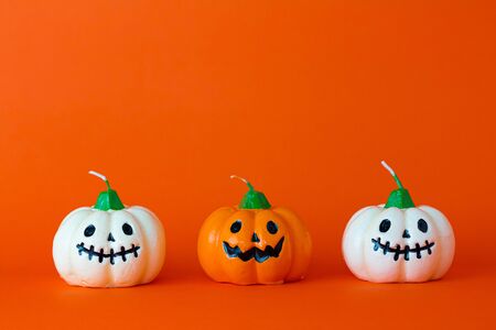 White and Orange ghost pumpkin on orange background with copy space ,  halloween concept.の写真素材