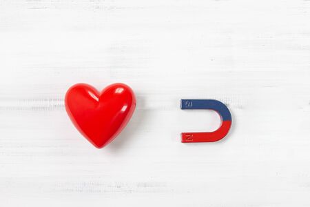 Magnet attracting Red Heart on white wood background. Love Concept with Copy Space.の写真素材