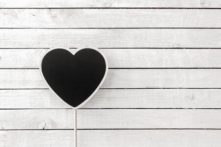 Heart Blackboard Shaped over white wood backgroundの写真素材