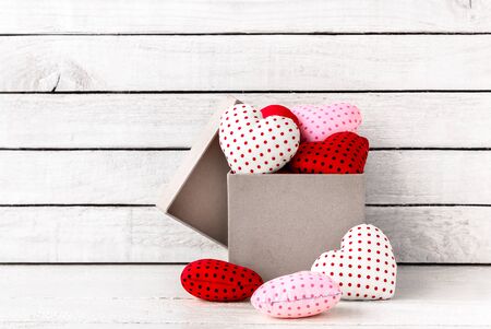 Many Red Heart Shaped with brown gift box over white wood backgroundの写真素材