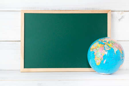 Greenboard with Globe sign on white wood background , empty board ,  education concept.の写真素材