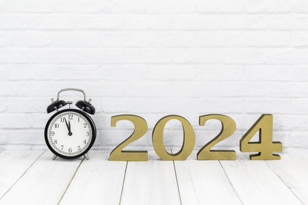 2024 new year & alarm clock on white wood table over white background with copy space , time conceptの写真素材