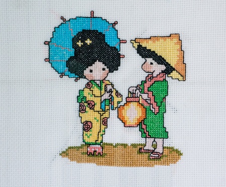 Cross stitch picture of Japanese boy and girl in national dress