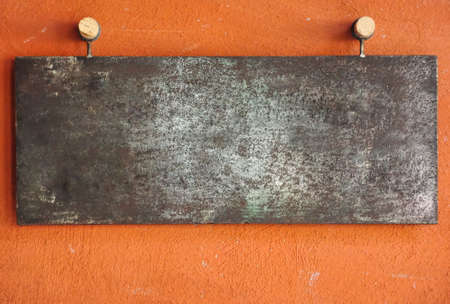 Vintage style picture of blank metal plate on orange wallの写真素材