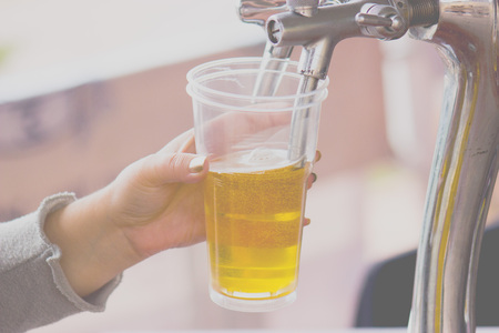 Pours beer into a plastic glassの写真素材