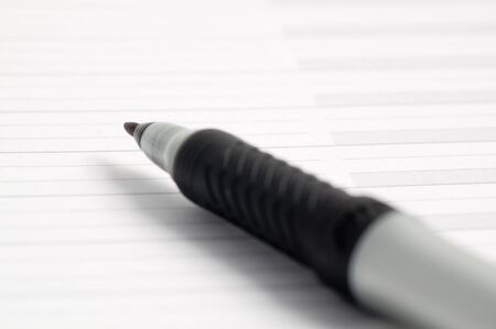 Black pen on a notepad with horizontal linesの写真素材