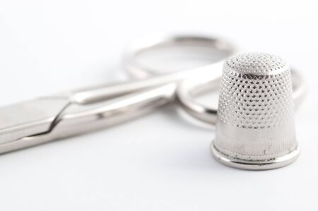 Closeup of scissors and thimble on a white backgroundの写真素材