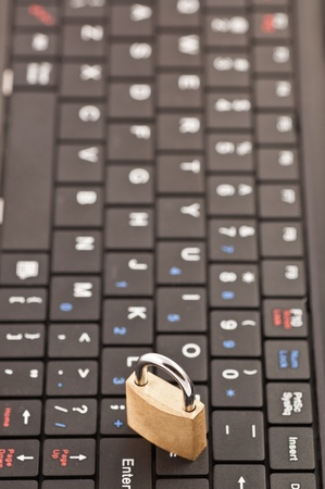 Padlock on the black keyboard of a netbook (vertical version)の写真素材