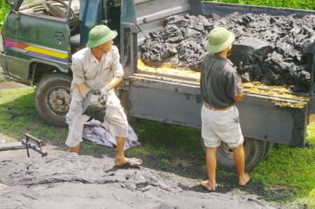 A truck difficulty probably dump its load of coal slurry on the flank of the dam  Two men with another truck trying to recover coal  This paste is a poor quality coal that contains a lot of ground, and mixed with a little water cylinder is used to make chのeditorial素材