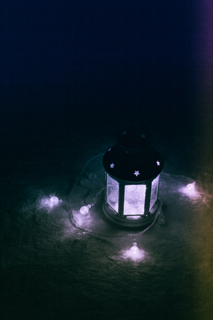 Holiday Greeting Card or Background. Christmas Lights and Candle Lantern on Dark Background. Christmas at Home. New Year Holiday Template.の写真素材