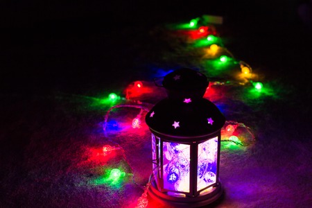 Holiday Greeting Card or Background. Christmas Lights and Candle Lantern on Dark Background. Christmas at Home. New Year Holiday Template.の写真素材