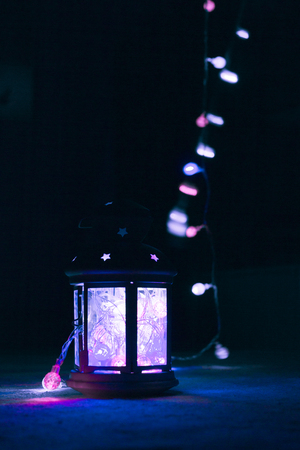 Holiday Greeting Card or Background. Christmas Lights and Candle Lantern on Dark Background. Christmas at Home. New Year Holiday Template.の写真素材