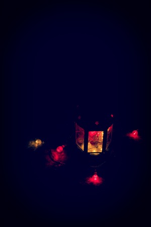 Holiday Greeting Card or Background. Christmas Lights and Candle Lantern on Dark Background. Christmas at Home. New Year Holiday Template.の写真素材