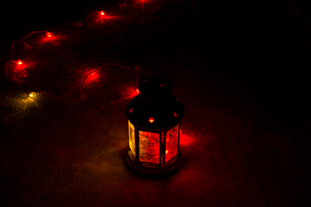 Holiday Greeting Card or Background. Christmas Lights and Candle Lantern on Dark Background. Christmas at Home. New Year Holiday Template.の写真素材