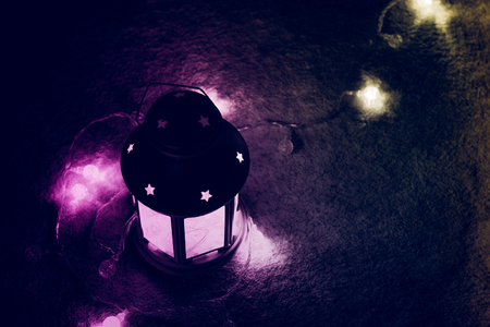 Holiday Greeting Card or Background. Christmas Lights and Candle Lantern on Dark Background. Christmas at Home. New Year Holiday Template.の写真素材