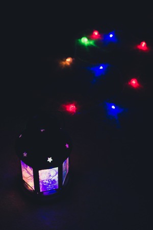 Holiday Greeting Card or Background. Christmas Lights and Candle Lantern on Dark Background. Christmas at Home. New Year Holiday Template.の写真素材
