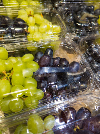 Close up of fresh grapes in plastic packaging on a store shelf