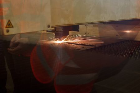 Industrial laser beam cuts pieces of brilliant metal. High quality photoの写真素材