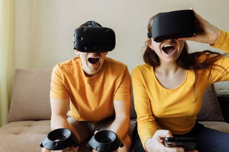 What to do at home. A guy and a girl emotionally play virtual games. People are wearing black...