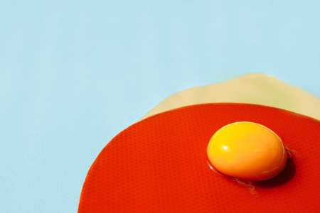 The liquid yolk lies on the red circle. The texture of a red circle with small polka dots of the same color. A circle of squirrels spread out and spilled onto the blue table. There is space for textの写真素材