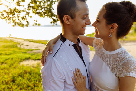 A man and a woman are smiling broadly at each other. Woman Hugs the mans shoulders. The atmosphere is summer and warm. High quality photoの写真素材