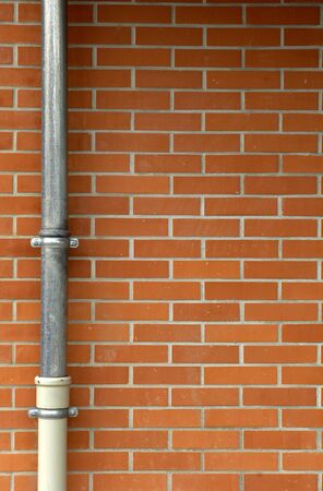 a drainpipe on a brick wall of a house