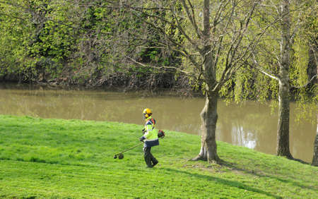 Ile de France, a gardener with a strimmer in a park