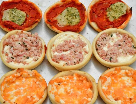 close up of small pizzas before being bakedのeditorial素材