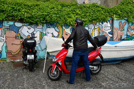 Funchal, Portugal - february 21 2018 : man with a scooter in the city centreのeditorial素材