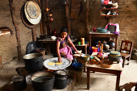 Zinacantan; United Mexican States - may 15 2018 : a woman is cooking tortillas in an Indian kitchenのeditorial素材