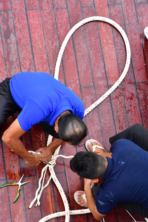 Kingdom of Cambodia - august 19 2018 : repairs of a rope on a boat