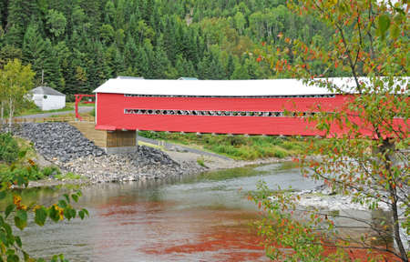 Quebec; Canada- june 25 2018 : a red covered bridge on Matapedia river in Gaspesieのeditorial素材