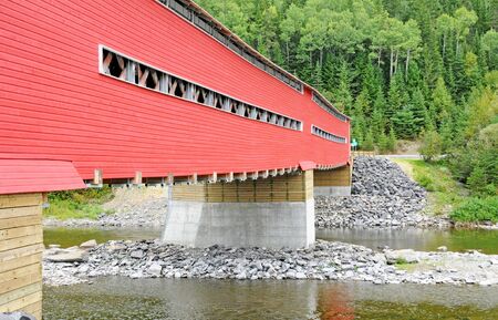 red covered bridge on Matapedia river in Gaspesieの写真素材