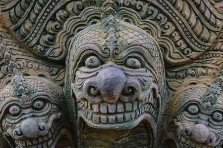Stone statue on the wall of the temple in Thailand.のeditorial素材