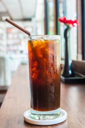 Iced black coffee on the wooden table in coffee cafe.の写真素材