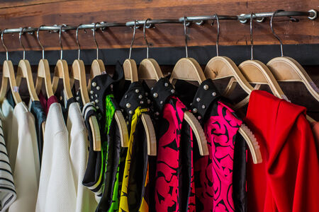 Many blouses on hangers in the dressing room 