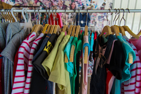Colorful blouse hanging on clothesline in a shop.の写真素材