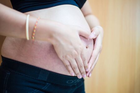 Closeup photo of belly of pregnant woman, body part, happy anticipation, new life conceptの写真素材