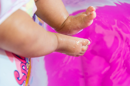 Baby foot touch the water.の写真素材