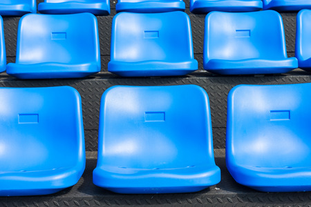 Blue seats on the grandstand of the football stadium.の写真素材