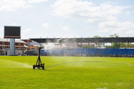 Sprinkler watering the grass of the football field.の写真素材