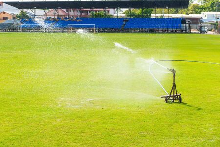 Sprinkler watering the grass of the football field.の写真素材